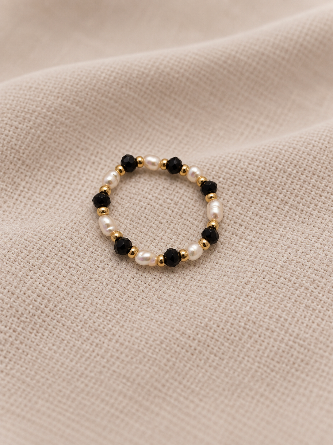 SEKINO Nomi Ring mit schwarzen facettierten Glasperlen, Süsswasserperlen und goldfarbenen Edelstahlperlen - Detailansicht